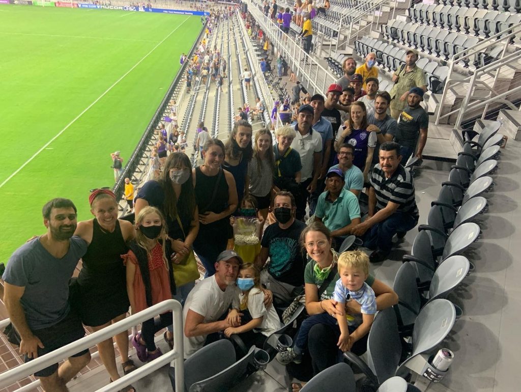 Rootbound's staff gathered together in stadium stands enjoying a soccer game.